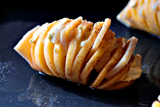 Scalloped hasselback potatoes step by step picture recipe. Slice the butter and Parmesan. Next, open the potatoes’ crevices and shove the Parmesan and butter, alternating between the two.